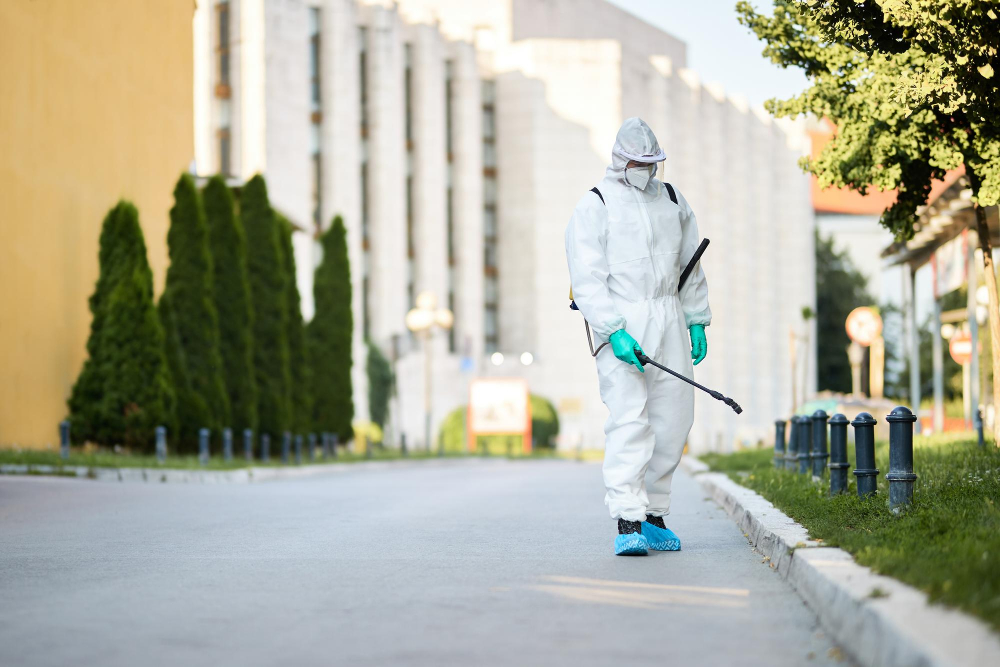 man in protective suit disinfecting city streets during coronavirus pandemic